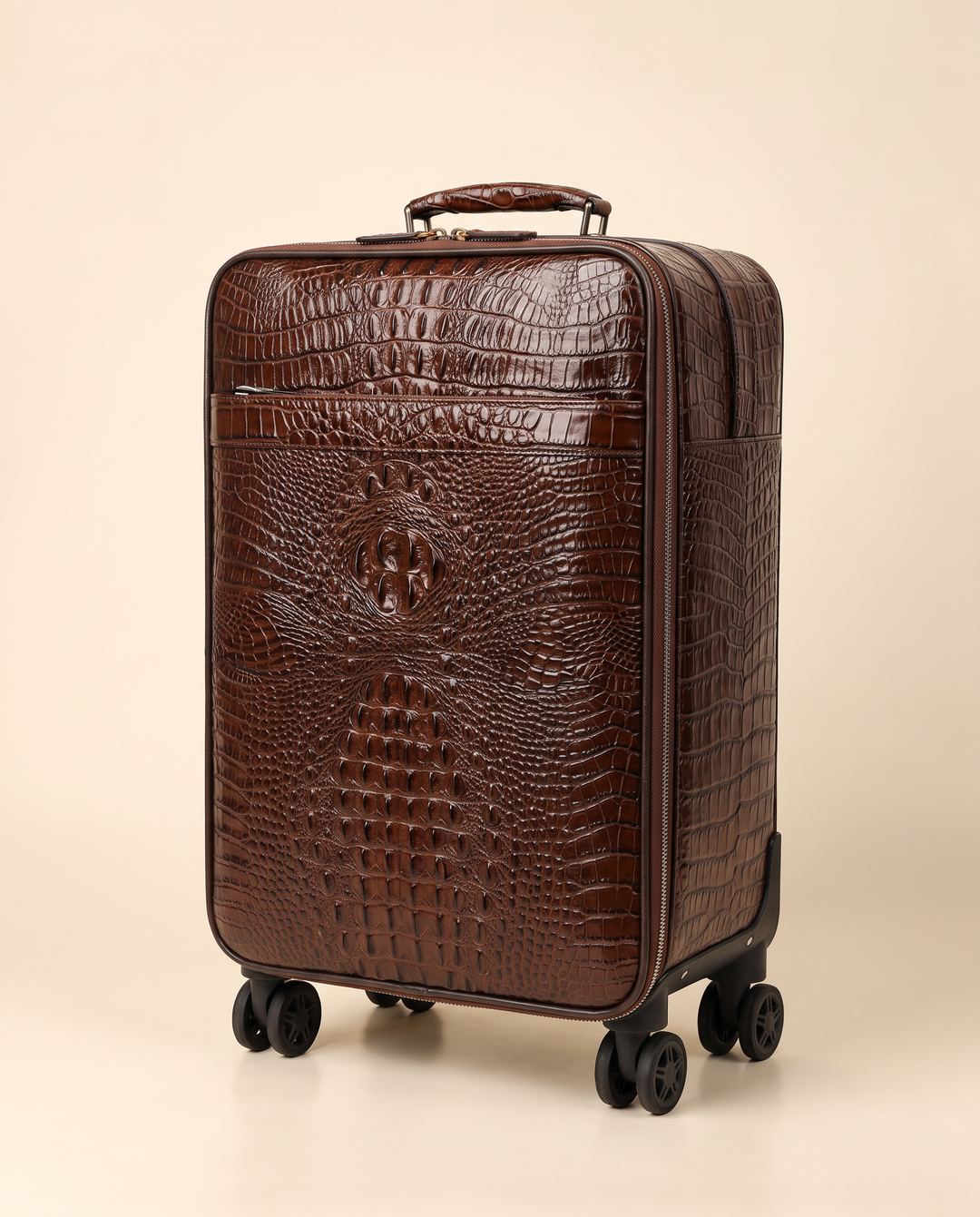 The Zermatt 58 crocodile trolley case in coffee brown, three-quarter view on a cream studio backdrop